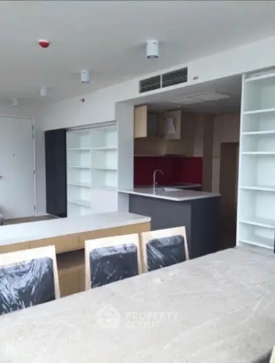 Modern open-layout kitchen with sleek cabinetry and dining area in a contemporary apartment.