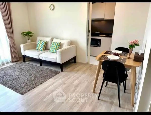 Charming open-plan living room with cozy dining area and modern kitchen.