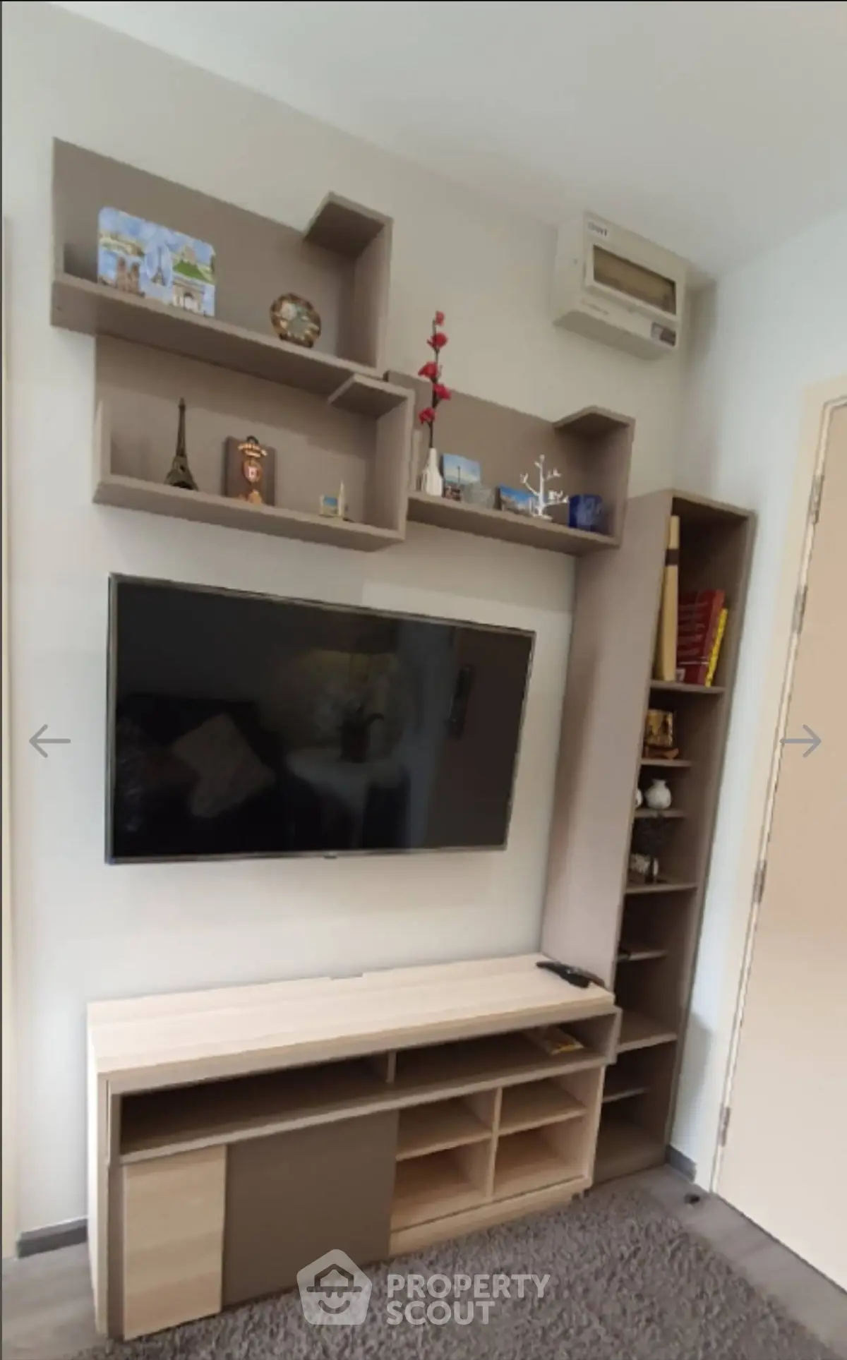 Modern living room with stylish shelving and wall-mounted TV