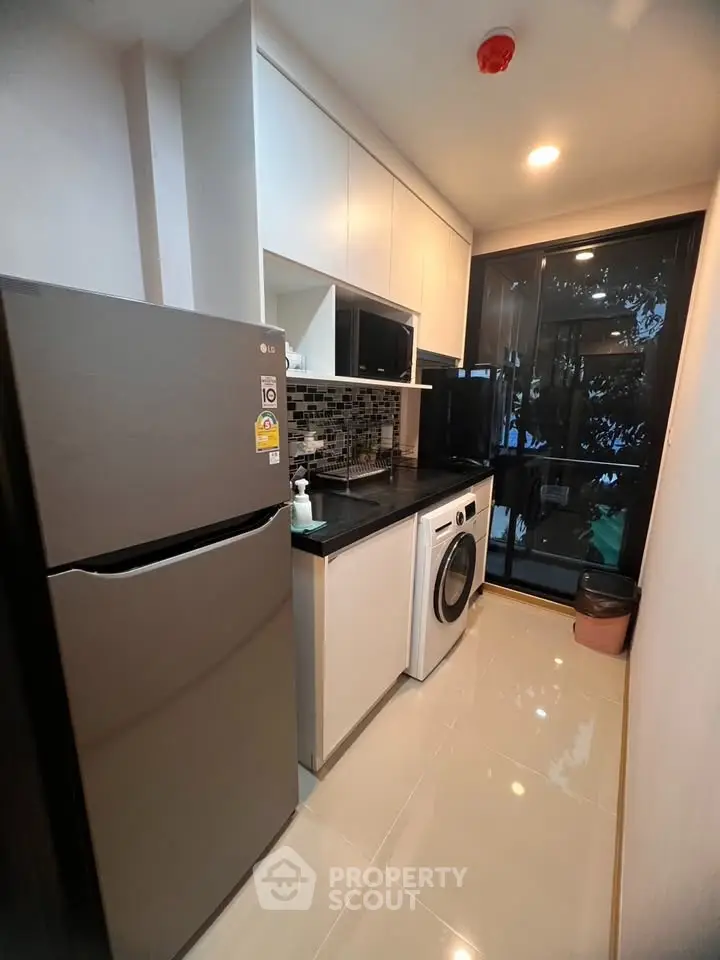 Modern compact kitchen with sleek appliances and stylish backsplash