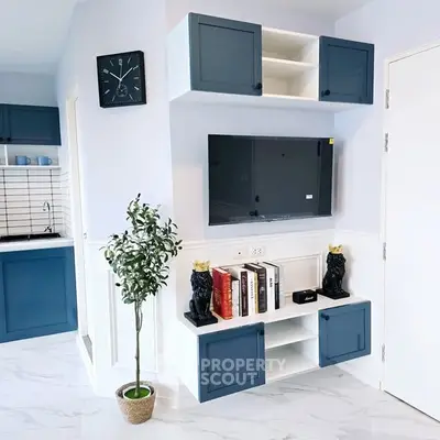 Modern living room with stylish blue cabinets and wall-mounted TV