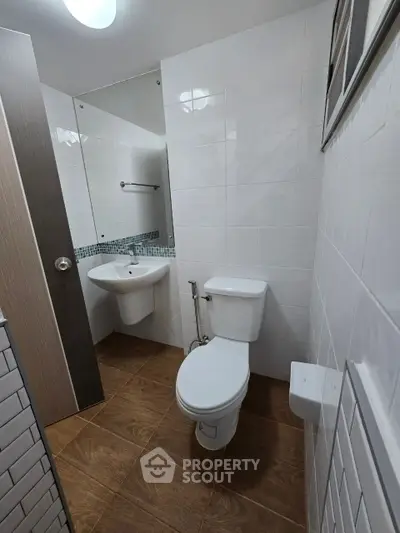 Compact modern bathroom with white tiles and wooden floor