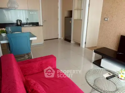 Modern living room with vibrant red sofa and compact kitchen area