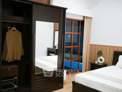 Modern bedroom with sleek wardrobe and cozy decor, perfect for relaxation and comfort.