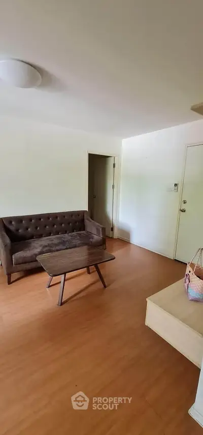 Cozy living room with brown sofa and wooden coffee table, perfect for relaxation.