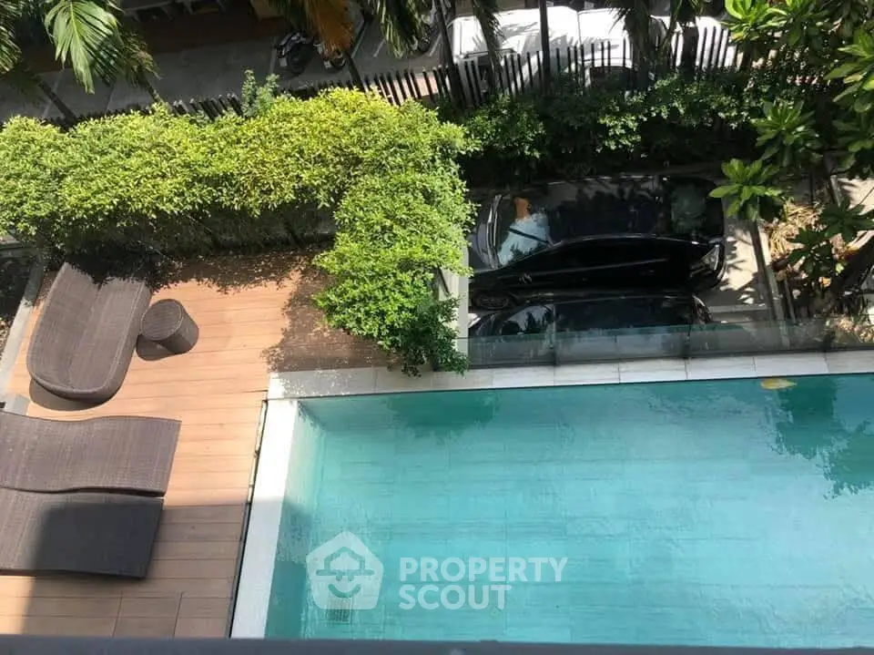 Luxurious poolside view with lush greenery and stylish outdoor seating.