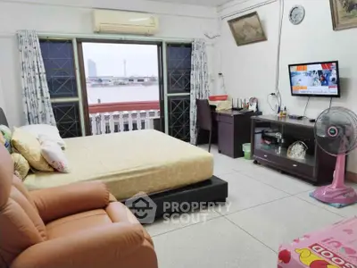 Spacious bedroom with city view, featuring cozy seating and modern amenities for comfortable living.
