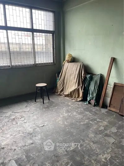 Spacious room with large window and natural light, ideal for renovation or creative projects.