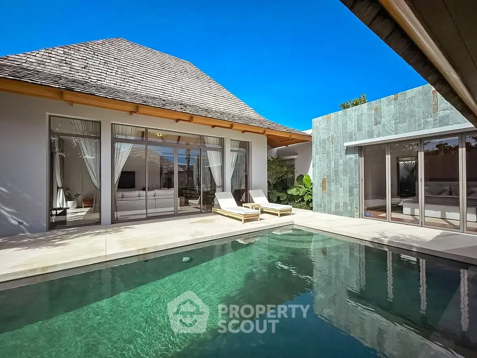 Luxurious villa with private pool and modern architecture under clear blue sky.
