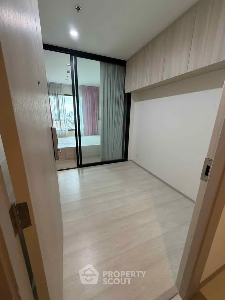 Spacious bedroom with sliding glass doors and ample natural light