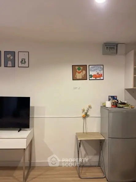 Cozy living room with modern decor and compact fridge, perfect for urban living.