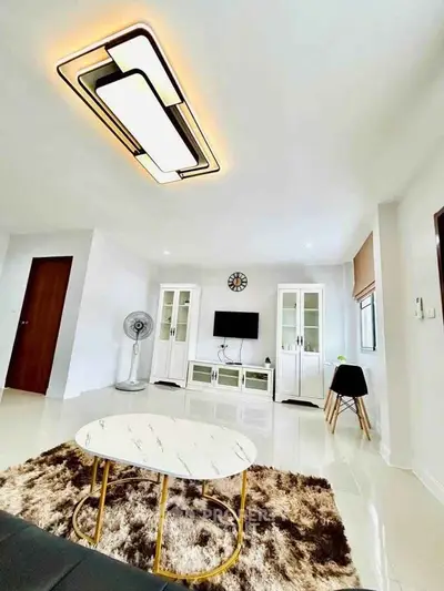 Spacious modern living room with stylish lighting and elegant decor, perfect for relaxation and entertainment.