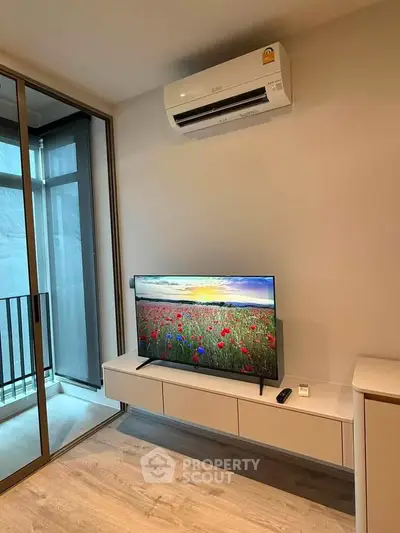 Modern living room with sleek TV setup and balcony view