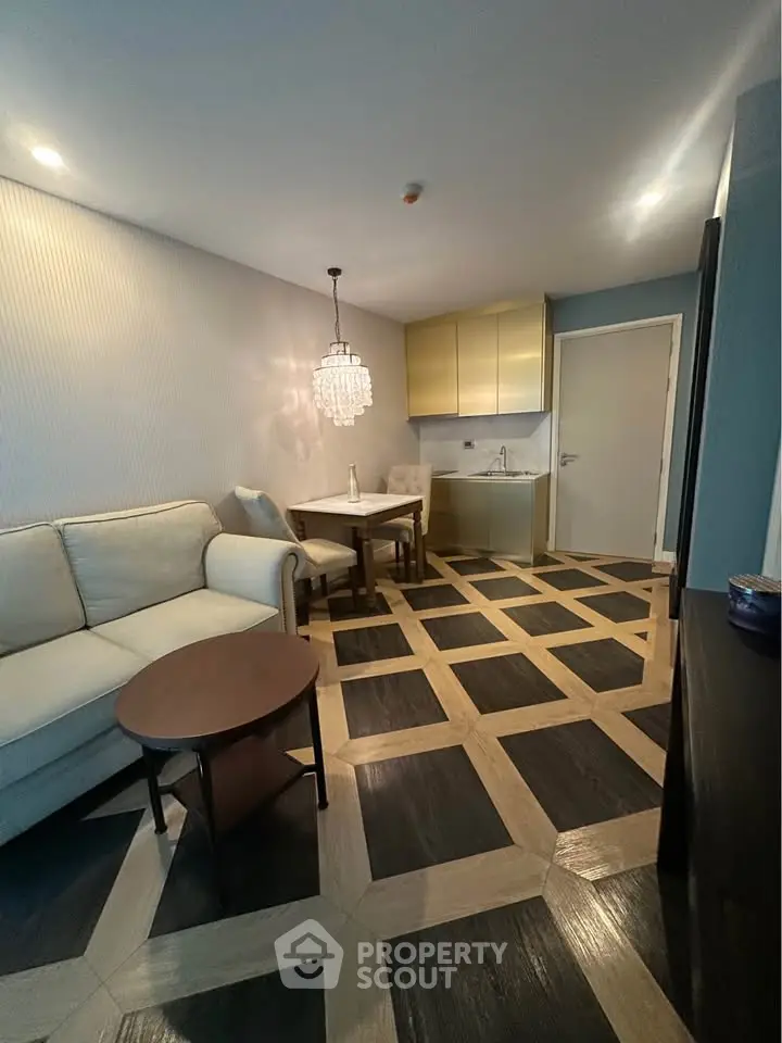 Modern living room with elegant chandelier and stylish flooring in a cozy apartment.
