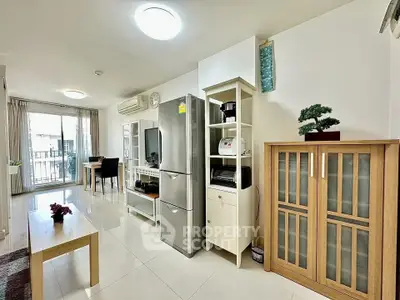Spacious modern living room with sleek furniture and natural light, featuring a large fridge and dining area.