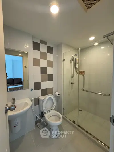 Modern bathroom with glass shower and sleek fixtures in a contemporary apartment.