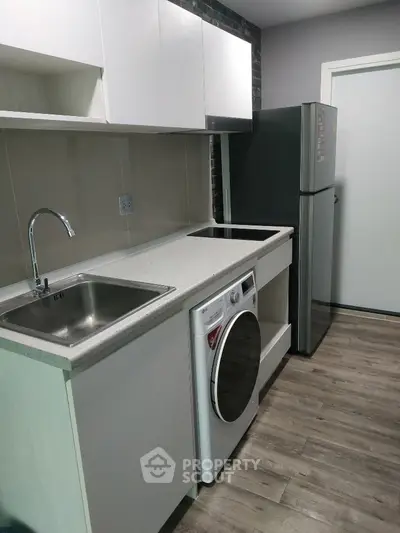 Modern kitchen with sleek appliances and stylish cabinetry in a compact layout.