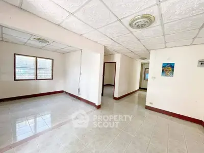 Spacious interior with tiled flooring and decorative ceiling tiles, ideal for customization.