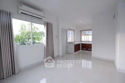 Bright and airy living space with large window and modern air conditioning unit.