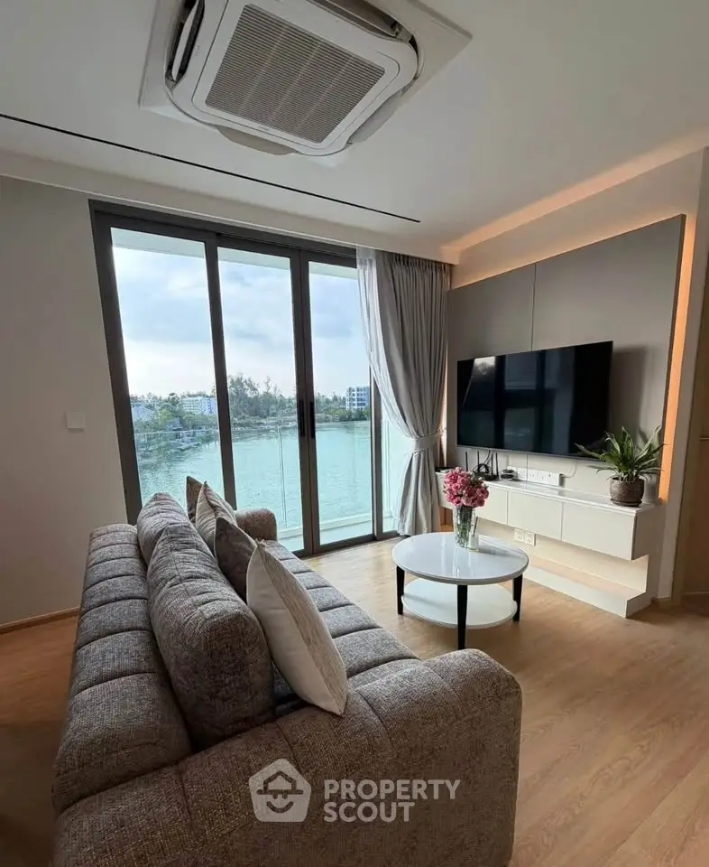 Modern living room with large windows and scenic water view