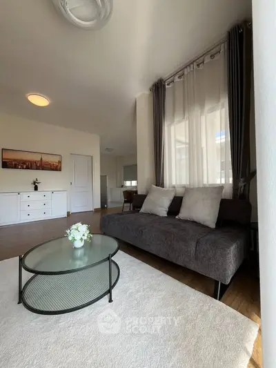Stylish living room with modern sofa, glass coffee table, and elegant decor in a bright apartment.