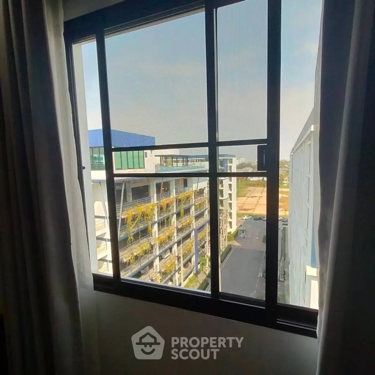 Modern apartment window view showcasing urban architecture and cityscape.