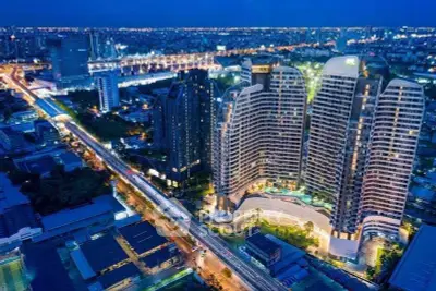 Stunning aerial view of modern high-rise buildings with city lights at night, showcasing urban luxury living.