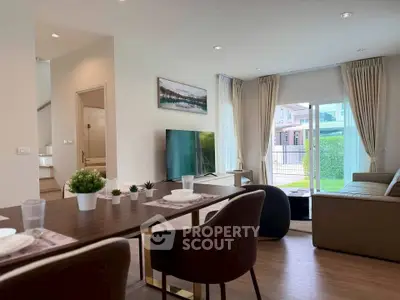 Modern living room with open layout and garden view, featuring stylish furniture and decor.