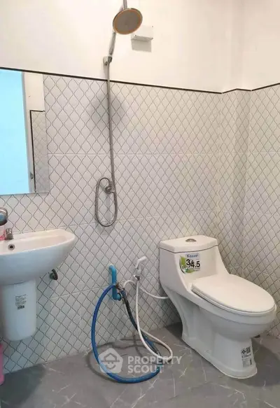 Modern bathroom with sleek shower and toilet design, featuring stylish tile patterns and contemporary fixtures.
