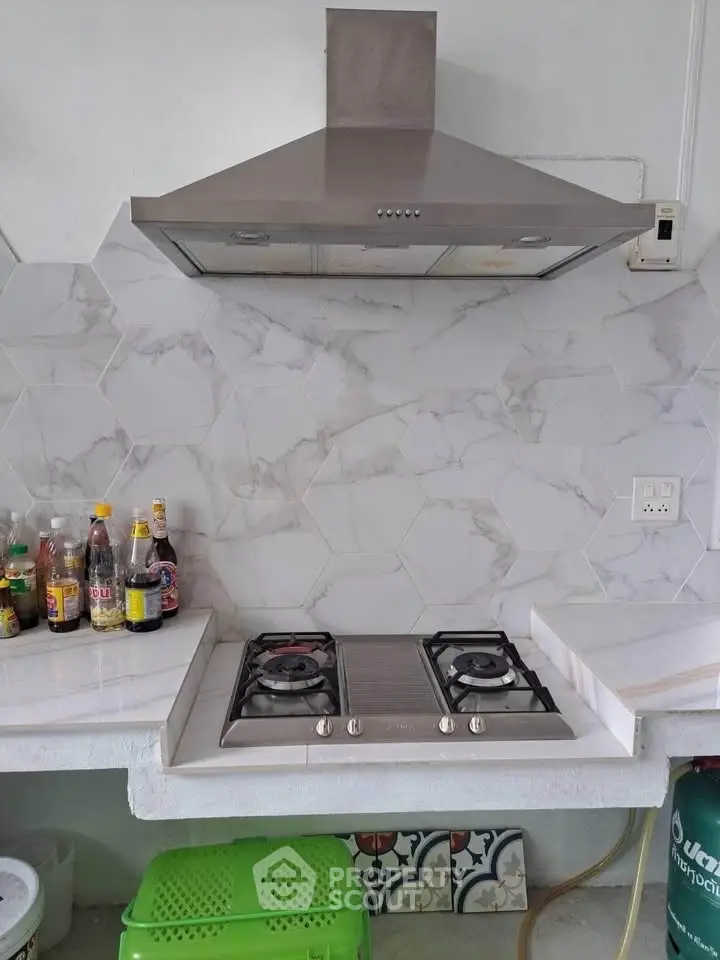 Modern kitchen with gas stove and stylish hexagonal backsplash tiles