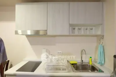 Modern kitchen with sleek cabinetry and induction cooktop in a compact layout.