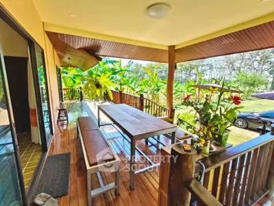 Charming wooden balcony with lush garden view, perfect for outdoor dining and relaxation.