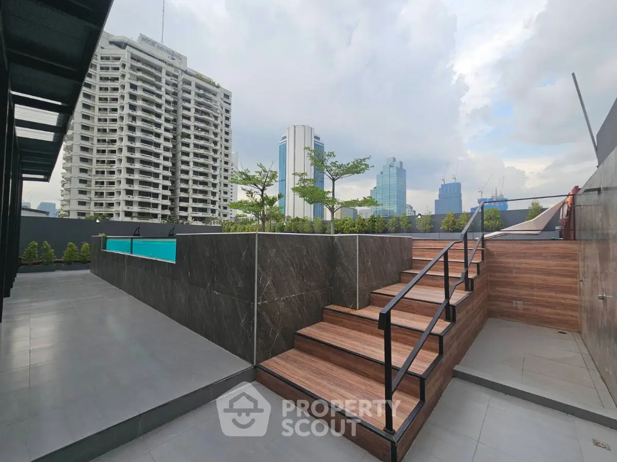 Modern rooftop with pool and city skyline view, featuring sleek design and urban ambiance.