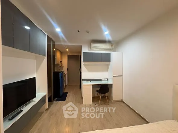 Modern studio apartment with sleek built-in furniture and cozy workspace.