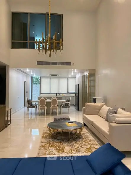 Luxurious modern living room with high ceilings and elegant chandelier