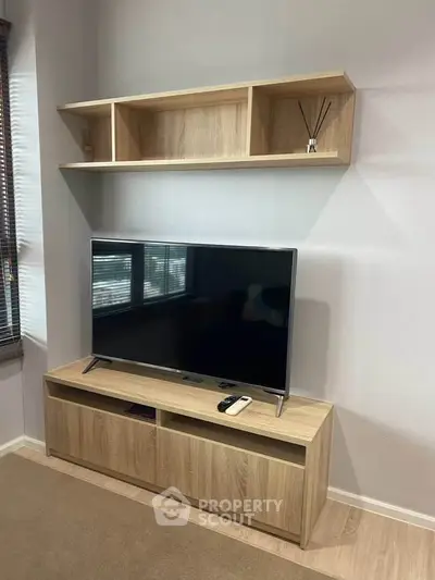 Modern living room with sleek TV stand and wall-mounted shelves, perfect for stylish home entertainment setup.