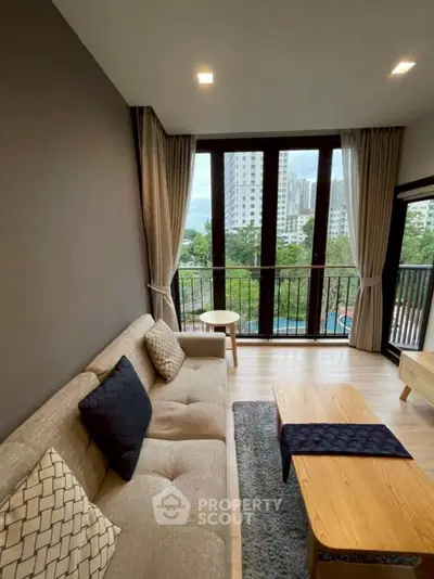 Modern living room with large windows and city view, featuring cozy sofa and stylish decor.