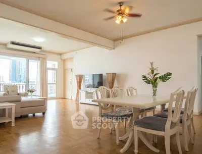 Spacious living and dining area with elegant furniture and city view.