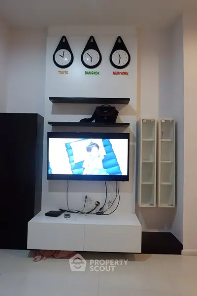 Modern living room with wall-mounted TV and world clocks