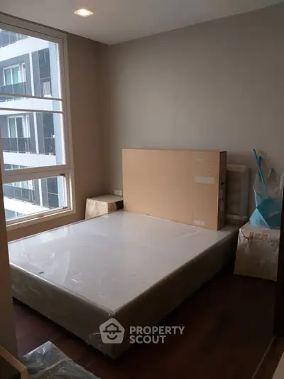 Cozy bedroom with large window and new mattress in modern apartment