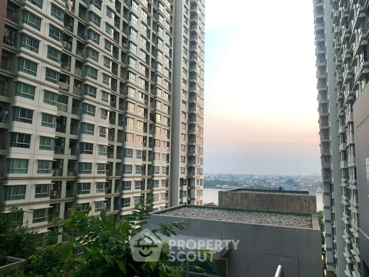 Stunning view between modern high-rise buildings with a glimpse of the river at sunset.