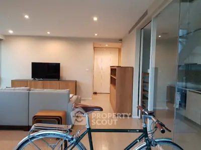 Modern living room with sleek furniture and bicycle, open layout design