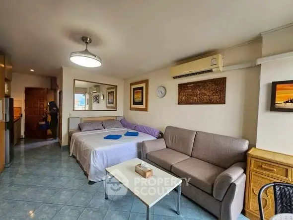 Cozy living room with sofa, bed, and modern decor in a compact apartment.