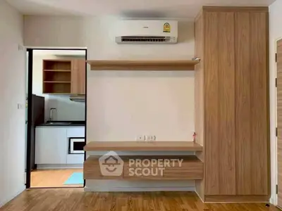 Modern apartment interior with wooden cabinetry and compact kitchen area.