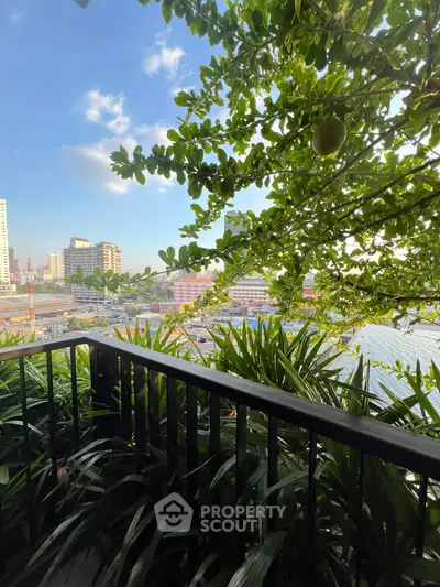 Stunning balcony view with lush greenery and cityscape backdrop.
