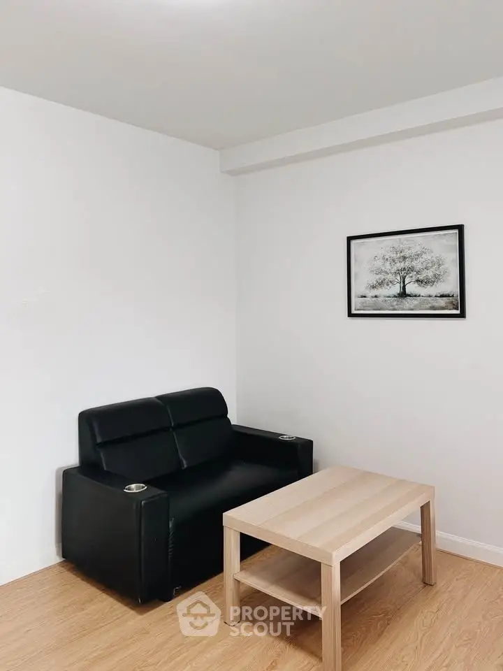 Minimalist living room with black sofa and wooden coffee table