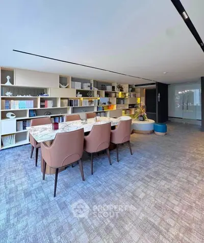 Spacious modern study room with elegant furniture and built-in bookshelves, perfect for work or meetings.