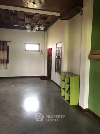 Spacious room with polished concrete floor and rustic wooden ceiling, ideal for creative renovation.