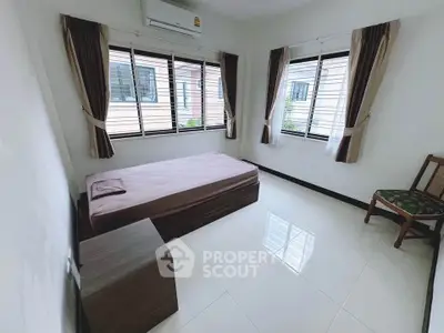 Bright bedroom with single bed and large windows in modern home