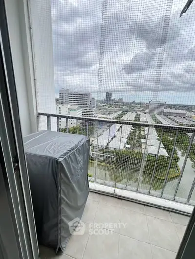 High-rise balcony with protective netting and cityscape view, ideal for urban living.